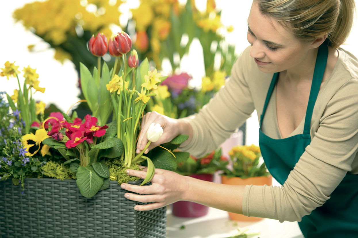 Fleuriste réalisant un bouquet de fleurs, chef d'entreprise adhérente au FAFCEA