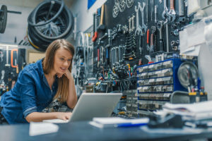 visuel d'une femme artisan dans son atelier de réparation de vélo